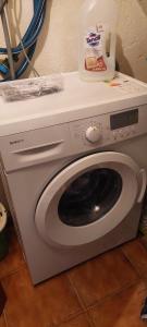 a white washing machine with a container on top of it at Casa da vila de Caria in Caria