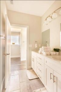 a white bathroom with a sink and a mirror at Burj Arab Luxury in Tower Grove