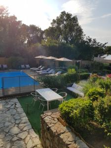 un jardín con mesa, sillas y piscina en Hotel Villa Maya, en Saint-Tropez