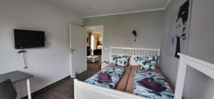 a small bedroom with a bed with pillows and a tv at MOIN & AHOI Ferienwohnung in Boiensdorf