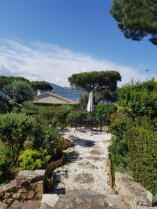 a stone path with an umbrella and a table and chairs at Hotel Villa Maya in Saint-Tropez