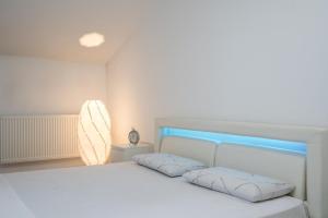 a white bed with two pillows in a bedroom at Smart Duplex in Bucharest
