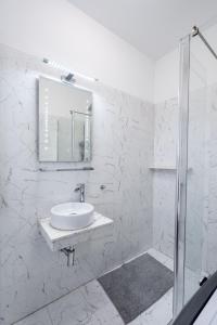 a white bathroom with a sink and a mirror at Smart Duplex in Bucharest