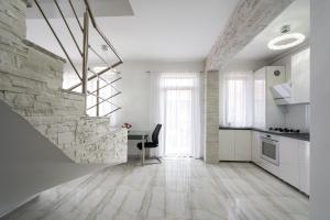 a kitchen with white walls and a stone wall at Smart Duplex in Bucharest