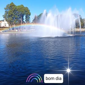 a fountain with a rainbow in the water with the words born data at Centro de Gramado in Gramado
