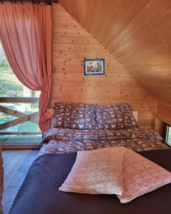 um quarto com uma cama num chalé de madeira em Domki na Górniej Łące - Domek Górny em Łazany