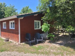 a small cabin with two chairs and a table at Camping Syl-Vallée Western Village in Bouglon