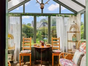 a conservatory with a table and chairs and a window at Ivy Cottage in Crieff