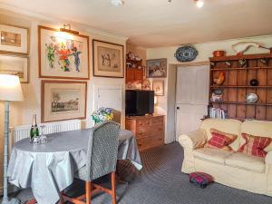 a living room with a table and a couch at Ivy Cottage in Crieff