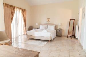 a bedroom with a white bed and two windows at Kos Secret Villa with private pool in (( Kermetés )) +38 photos
