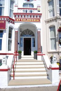 - un bâtiment blanc avec des escaliers menant à la porte d'entrée dans l'établissement At Caledonia, à Douglas