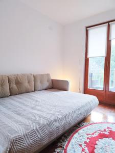 a couch sitting in a living room with a window at Apartman 5ra in Vrnjačka Banja
