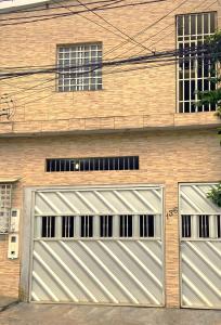 duas portas de garagem ao lado de um edifício de tijolos em Apartamento 3 Aconchegante São Jorge em Manaus