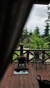 a woodburning stove on a deck with a table and chairs at Domki na Górniej Łące - Domek Górny in Łazany