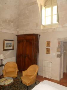 ヴィルヌーヴ・レ・ザヴィニョンにあるLe Cloitre du Couventのベッドルーム1室(椅子2脚、木製キャビネット付)