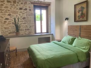 a bedroom with a green bed and a window at La Maison du Parc in Saint-Vite