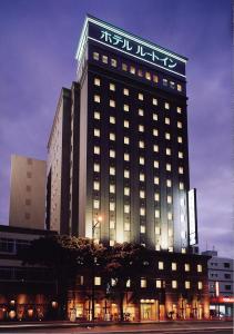 a large building with a sign on top of it at Hotel Route-Inn Nahatomariko in Naha