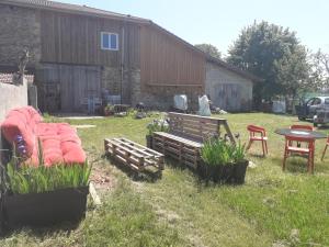 einen Hof mit einer Bank, einem Tisch und Stühlen in der Unterkunft La fermette in Saint-Marcellin