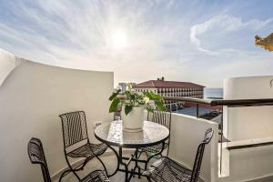 balcón con mesa, sillas y vistas en Elegant Beachfront Duplex with Private Parking, en Herzelia 
