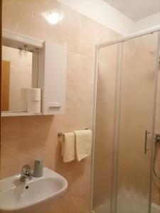 a bathroom with a white sink and a shower at Apartments Feral in Saplunara