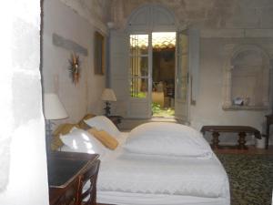 ヴィルヌーヴ・レ・ザヴィニョンにあるLe Cloitre du Couventのベッドルーム(白いベッド1台、窓付)