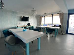 a kitchen with two tables and chairs in a room at Paradisul Verde in Jurilovca