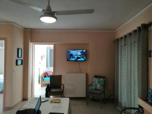 ein Wohnzimmer mit einem TV an der Wand in der Unterkunft Marios View in Saronida