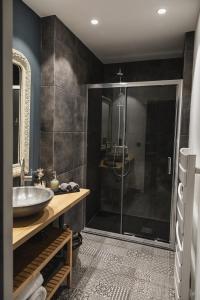 a bathroom with a glass shower and a sink at La Bastide de Barbizon in Barbizon