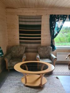 ein Wohnzimmer mit einem Tisch und 2 Stühlen in der Unterkunft Mukavä mökki luonnon rauhassa maaseudulla. in Kokemäki