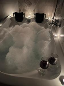 a bath tub filled with snow with two glasses of wine at La Mary in Old Town in Sibiu
