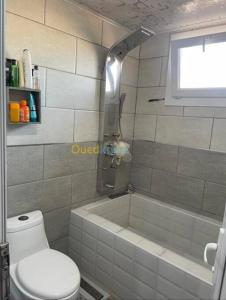 een badkamer met een douche, een toilet en een bad bij Appartement Ghazaouet in Ghazaouet