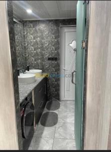 een badkamer met een wastafel, een toilet en een deur bij Appartement Ghazaouet in Ghazaouet