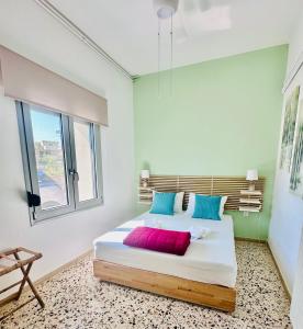 a bedroom with a large bed with blue and red pillows at Golden Key apartments in Chania Town