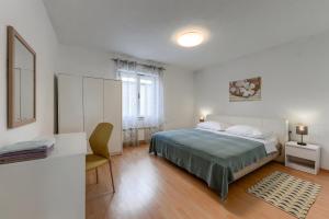 - une chambre avec un lit, un bureau et une table dans l'établissement Apartman Klarin, à Zadar
