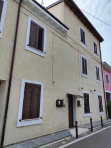 a tan building with brown shutters on a street at House Verona Zen in Verona