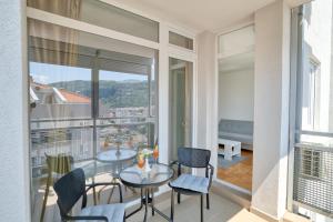 a room with a table and chairs and a balcony at Sigma apartment in Budva