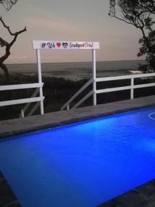 uma piscina azul em frente a uma cerca com uma placa em Southport Coral em Southport