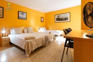 um quarto de hotel com duas camas e uma secretária em Villa Tambora- Costa Brava em Lloret de Mar