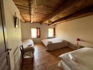 een slaapkamer met 2 bedden en een houten plafond bij Grand Gîte Confortable en Auvergne - Belle vue in Brousse