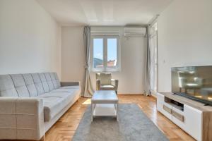 a living room with a couch and a television at Sigma apartment in Budva