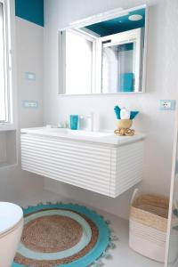 bagno con lavandino bianco e specchio di AMAREA Exclusive Suites a San Felice Circeo