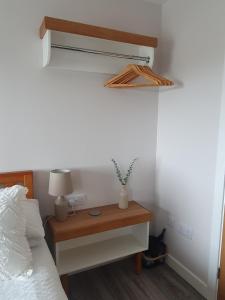 1 dormitorio con 1 cama y 1 mesa con lámpara en Self catering. Maydene. Holm. Orkney, Scotland., en Nether Button