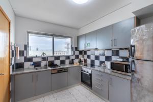 a kitchen with stainless steel appliances and a window at Atlantic West Town in Ponta Delgada +7 photos