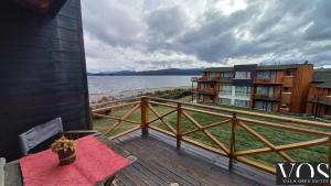 a deck with a bench and a view of the water at Villa Ober Suites in Dina Huapi