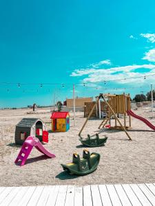 a playground with play equipment in the sand at Hotel Victory in Mamaia