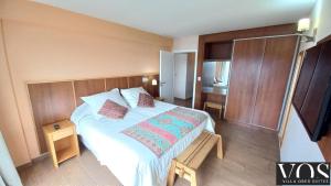 Schlafzimmer mit einem großen Bett mit einem Kopfteil aus Holz in der Unterkunft Villa Ober Suites in Dina Huapi