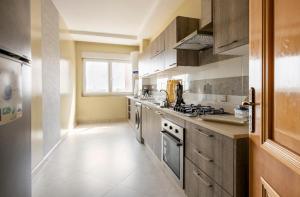 uma cozinha com utensílios de aço inoxidável e armários de madeira em Appartement 32 Ensoleillé à 5min de la Plage em El Jadida