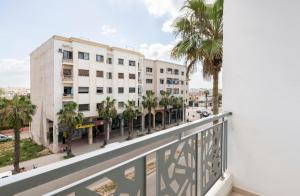 uma varanda com vista para uma rua e edifícios em Appartement 32 Ensoleillé à 5min de la Plage em El Jadida