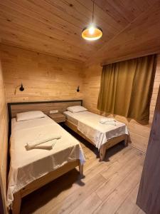 キラリにあるCirali Hotelの木造キャビン内のベッドルーム1室(ベッド2台付)