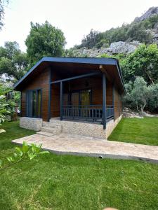 a small house with a porch on a grass field at Cirali Hotel in Cıralı